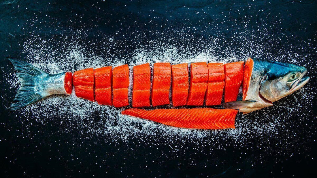 Whole sockeye salmon skinned and cut into portions on a dark background