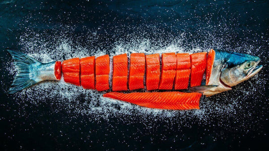 Whole sockeye salmon skinned and cut into portions on a dark background