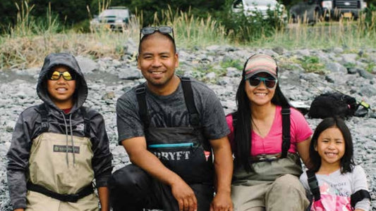 Alaskan family posing for photo on rocky shoreline